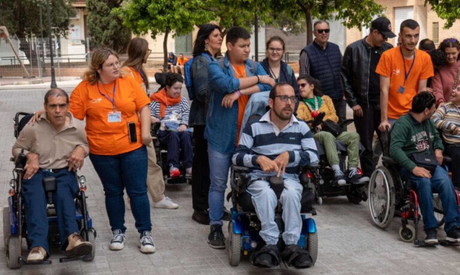 Grupo de personas, con personal de Asprona y personas en silla de ruedas, paseando por la calle