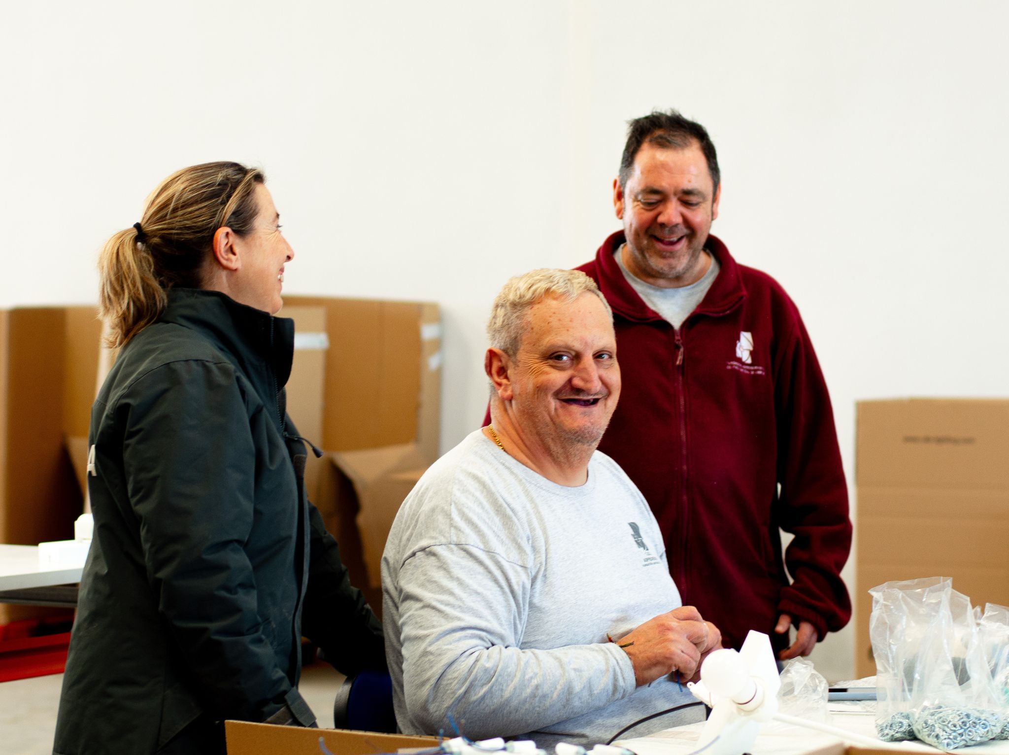 Tres personas sonrientes trabajando en un almacén